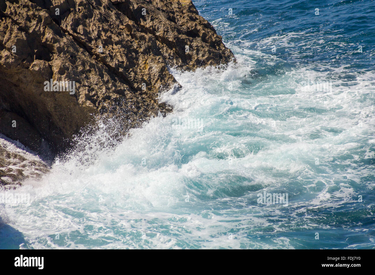 En mer, les vagues se brisant sur les rochers avec mousse blanche Banque D'Images