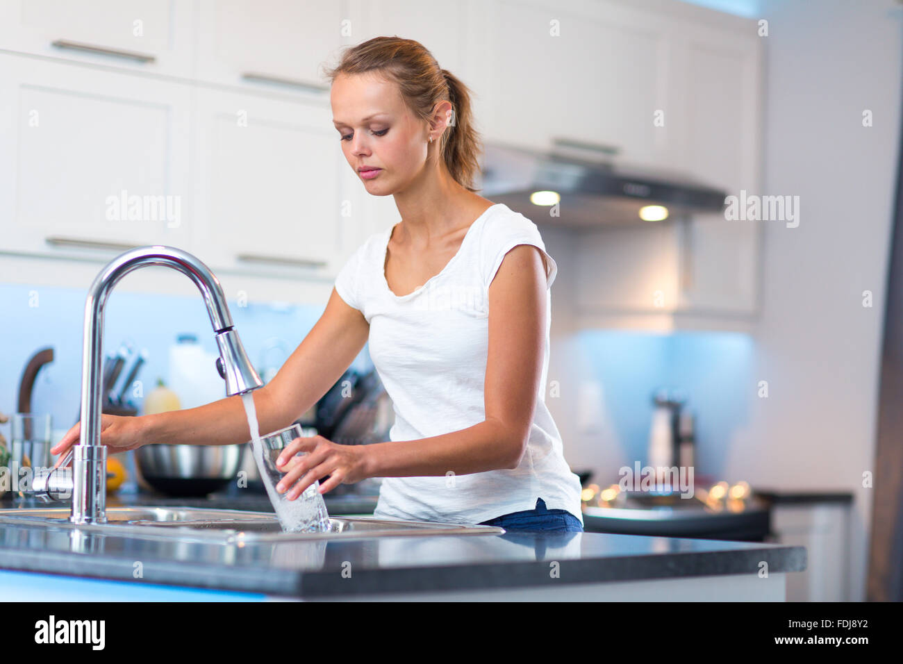 Девушка пьет из кувшина. Девушка пьет воду на кухне. Наливает воду. Девушка наливает воду на кухне. Воду наливают в стакан.