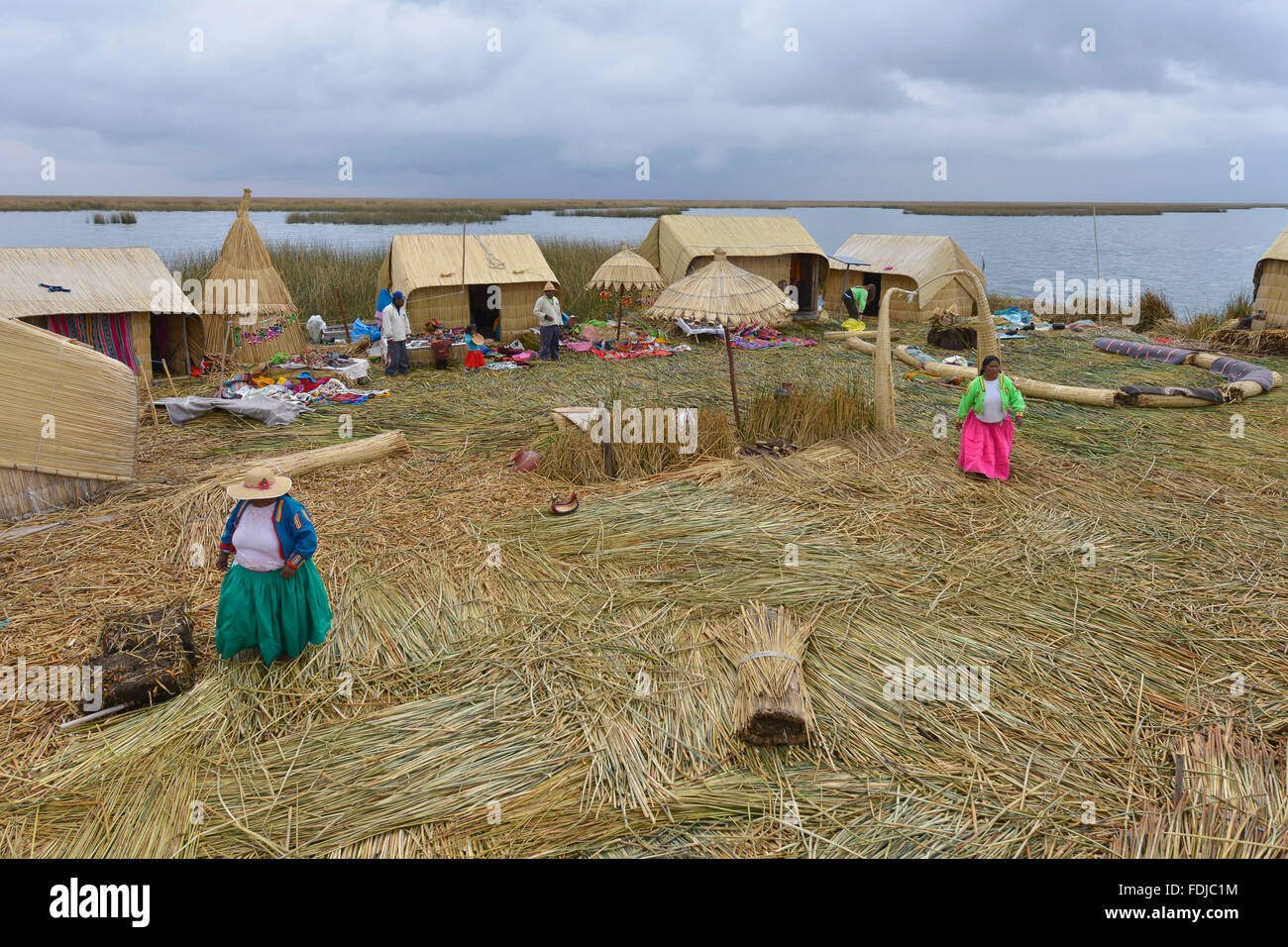 Lac Titicaca, Pérou - 5 septembre 2015 : les populations locales dans des atours traditionnels accueillir les touristes venant par bateaux en îles Uros. Banque D'Images