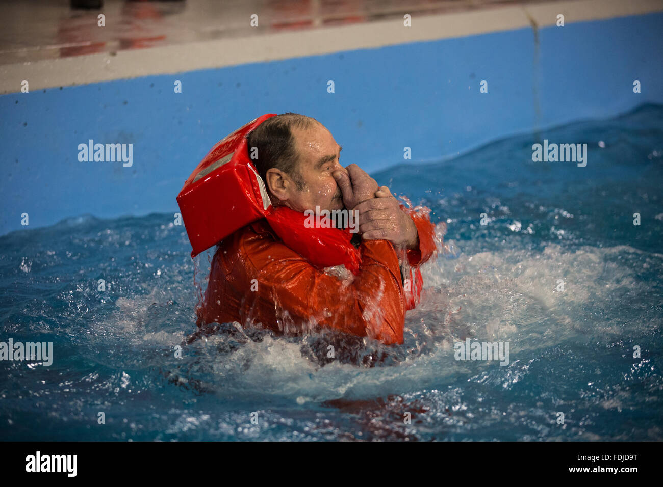 Un travailleur étranger au cours de la formation à la survie en mer Le port d'un gilet de re-surfaces au cours de la formation à la survie en mer. Banque D'Images