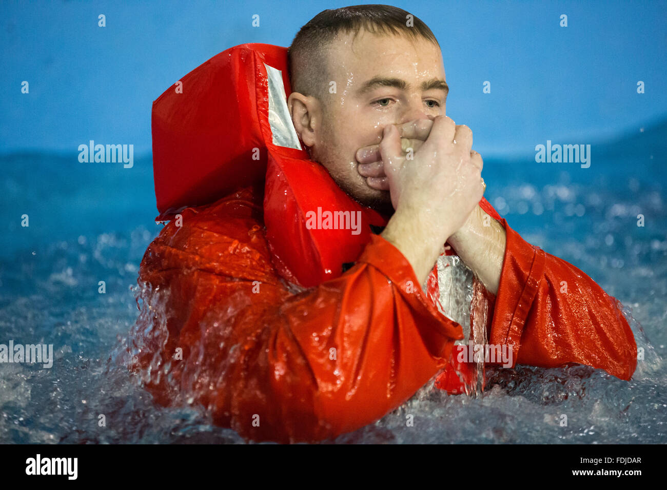 Un travailleur étranger au cours de la formation à la survie en mer Le port d'un gilet de re-surfaces au cours de la formation à la survie en mer. Banque D'Images