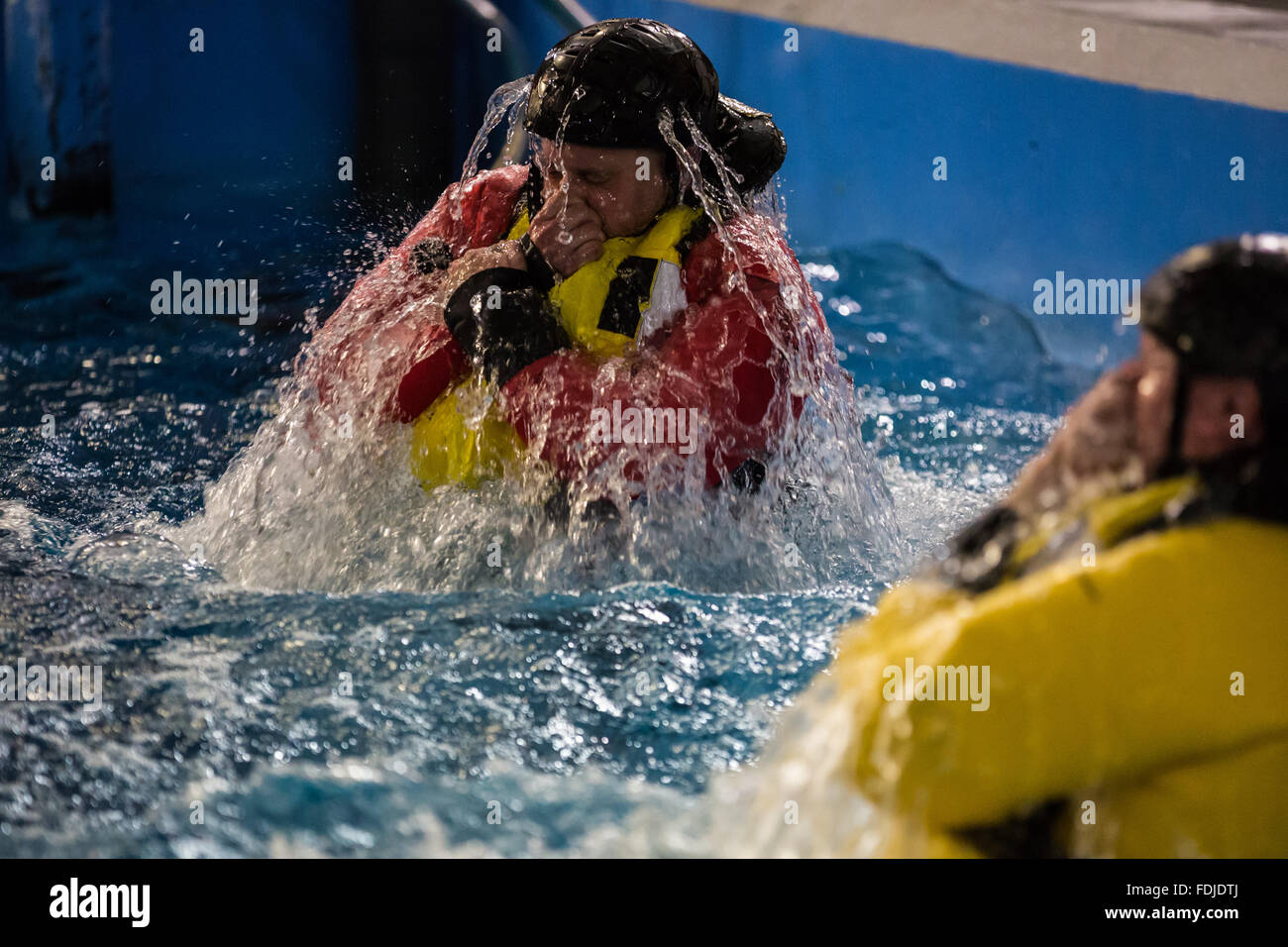 Un travailleur étranger au cours de la formation à la survie en mer Le port d'un gilet de re-surfaces au cours de la formation à la survie en mer. Banque D'Images