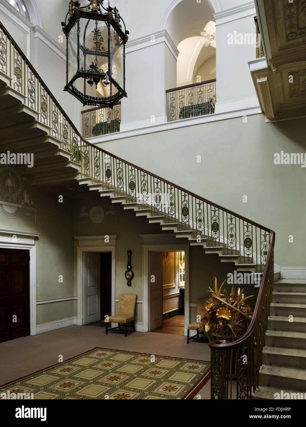 Le grand escalier, conçu par John Carr de York, au parc de Basildon, Berkshire. L'escalier est en surplomb du mur avec une balustrade en fer forgé décoré de médaillons de putti et chiffres en plomb moulé classique. La lanterne est de Banque D'Images