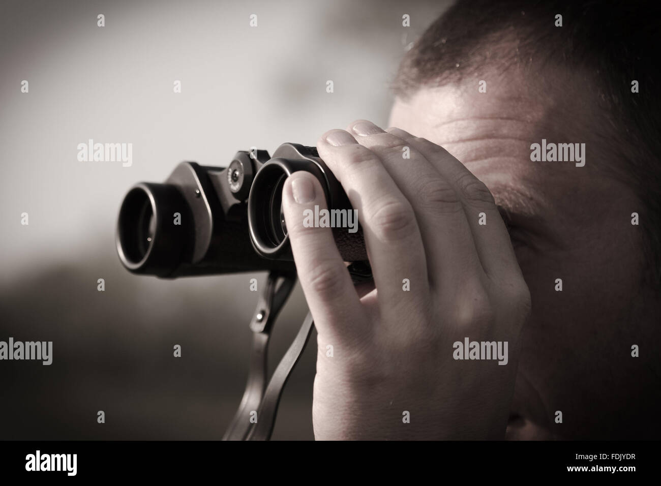 Man looking through binoculars Banque D'Images