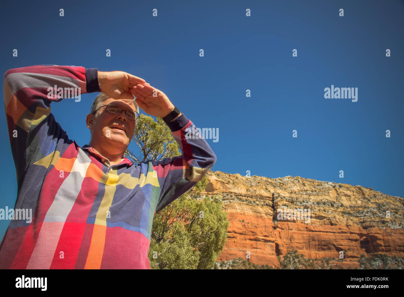 Homme protégeant les yeux regardant la vue, Sedona, Arizona, États-Unis Banque D'Images