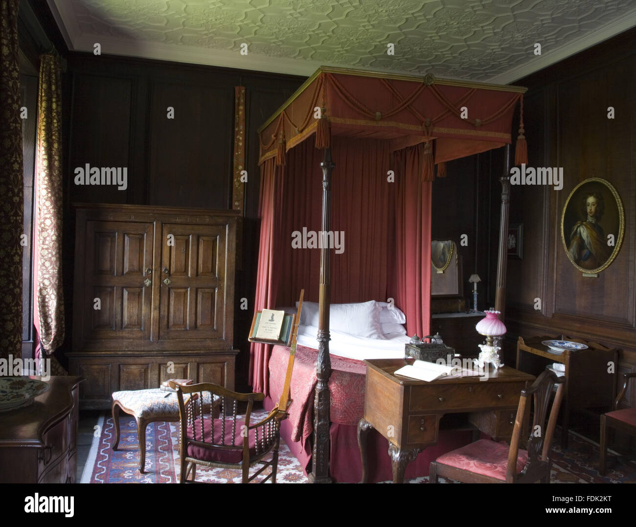 La chambre rouge à Erddig, Wrexham, Wales. Le lit à baldaquin en acajou est Chippendale-période d'environ 1760 incorpoartes et un mécanisme de levage de la tête ou sur les côtés. Le lit des tentures, date du milieu du xixe siècle. L'armoire suspendue chêne t suivant Banque D'Images