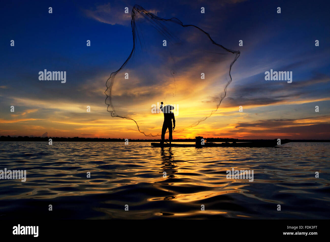 Silhouette d'un homme lançant filet de pêche, Mékong, Sangkhom, Thaïlande Banque D'Images