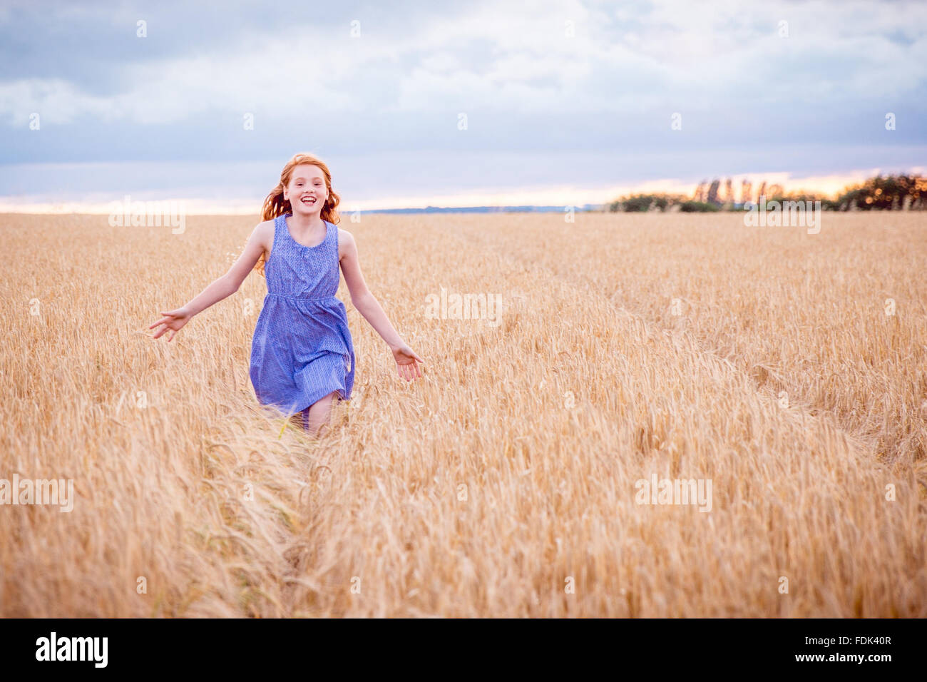 Portrait d'une fille courir à travers champ d'orge Banque D'Images