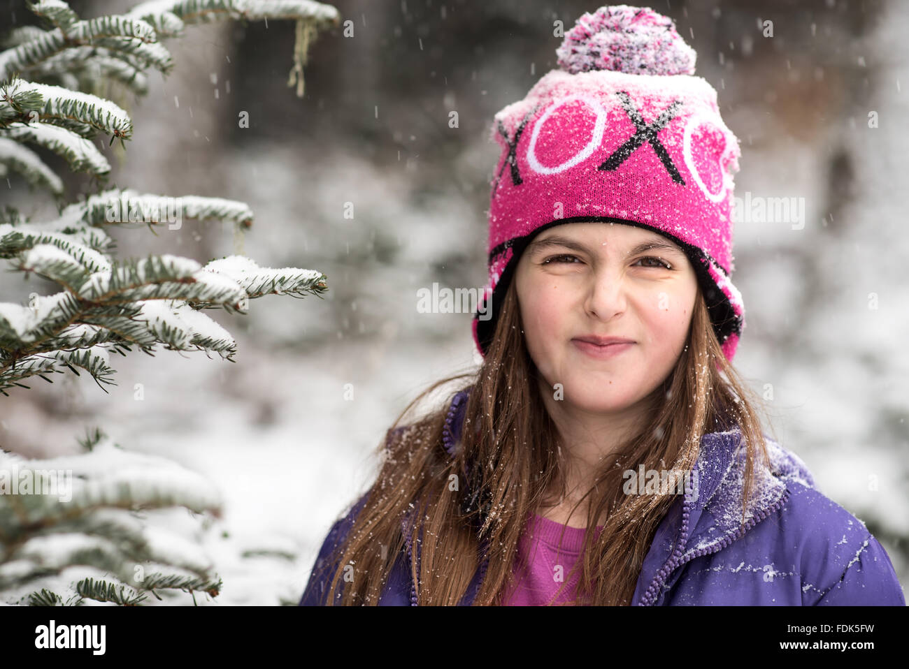 Smiling girl debout dans la forêt dans la neige Banque D'Images