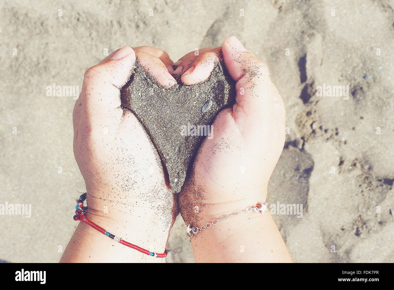 Hands holding sand en forme de coeur Banque D'Images