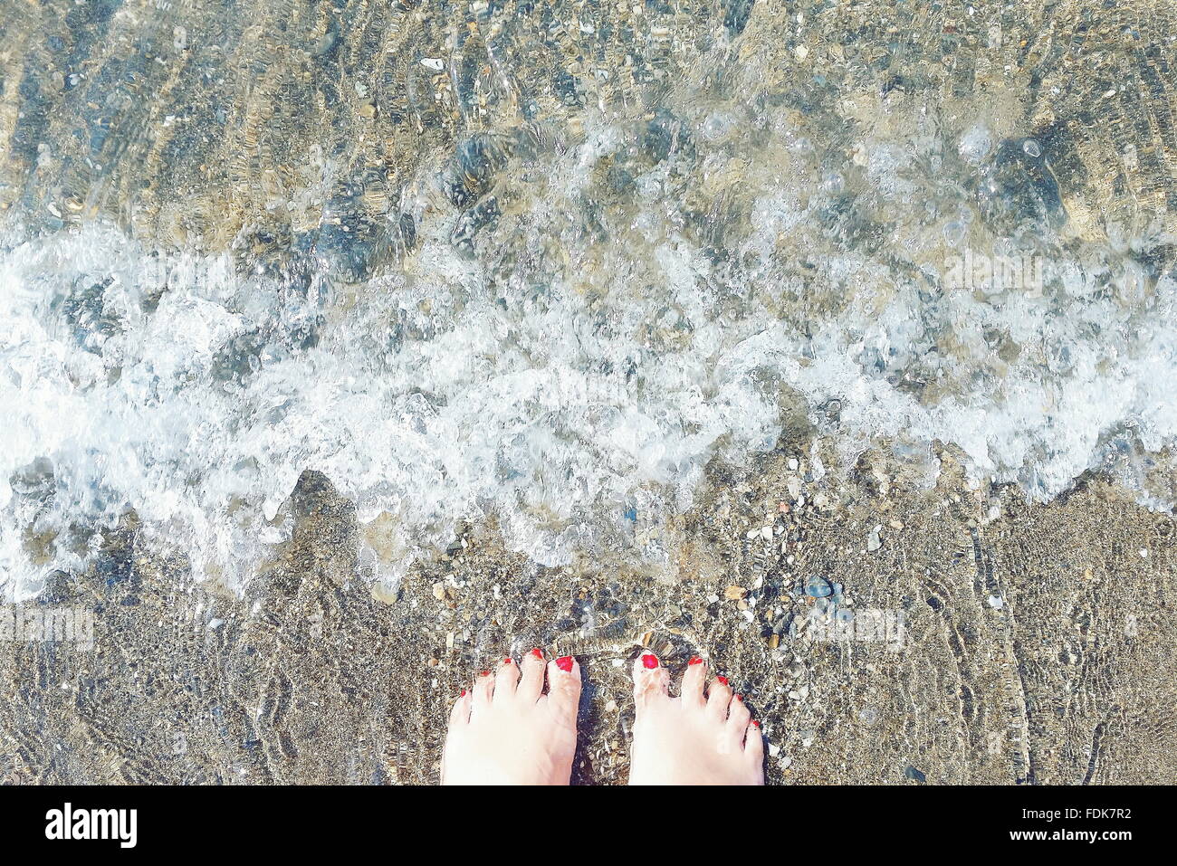 Pieds de femme debout au bord de l'eau, Malaga, Andalousie, Espagne Banque D'Images