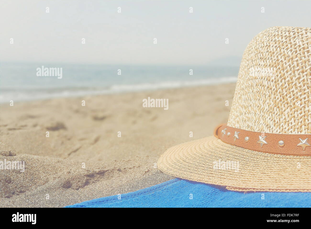 Chapeau de paille et une serviette sur la plage Banque D'Images