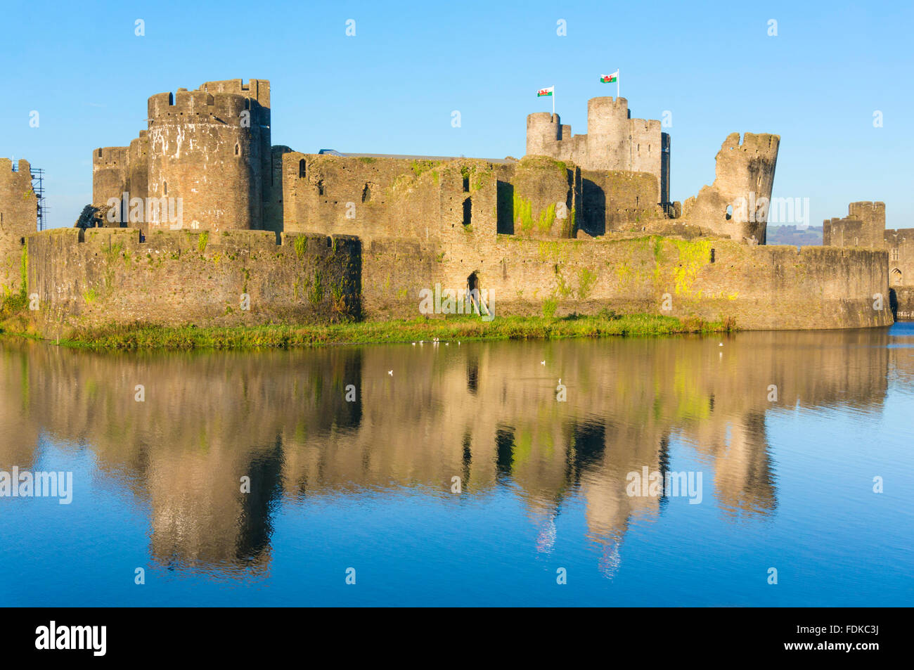 Volant au-dessus des drapeaux gallois Caerphilly Castle un château médiéval avec douves à Caerphilly Glamorgan South Wales GB UK EU Europe Banque D'Images