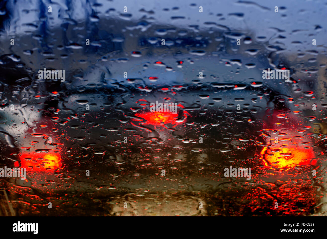 Les feux arrière d'une voiture vu à travers le pare-brise on a rainy day Banque D'Images