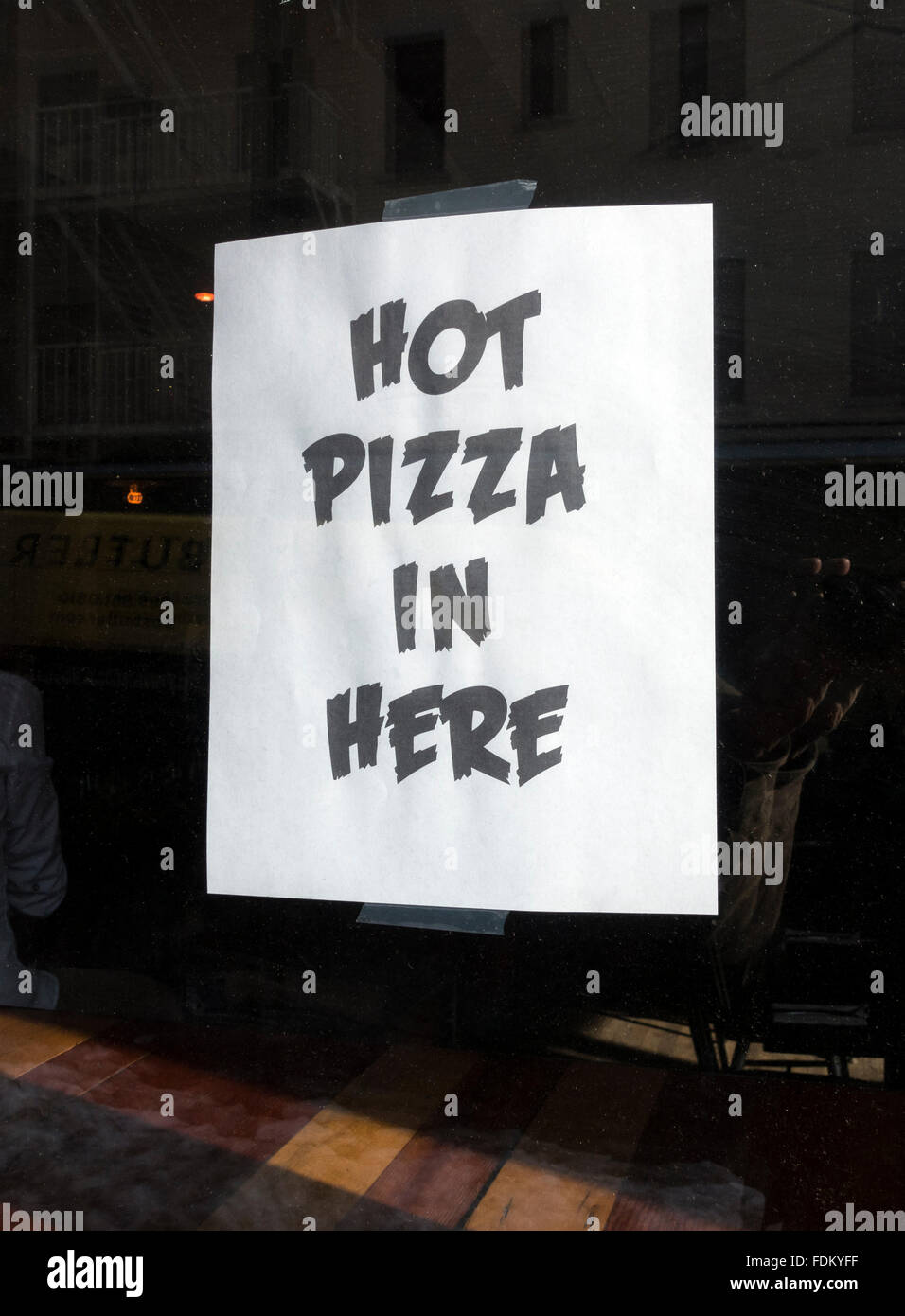 'Hot Pizza à ici' dans la fenêtre d'une pizzeria de NYC Banque D'Images