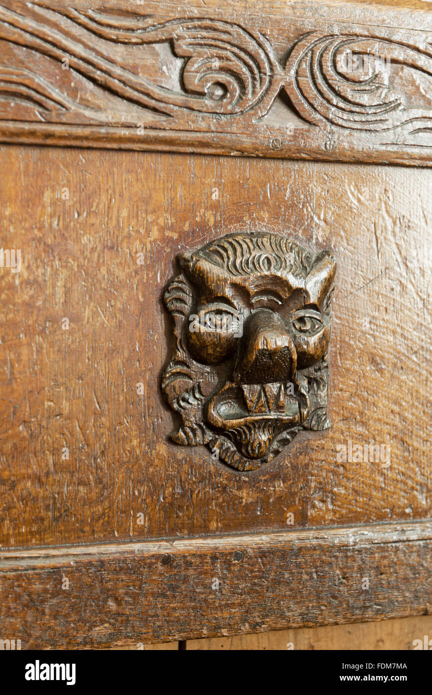 Détail sculpté d'une tête de lion sur un coffre en bois dans la salle à manger à Coughton Court, Warwickshire. Banque D'Images