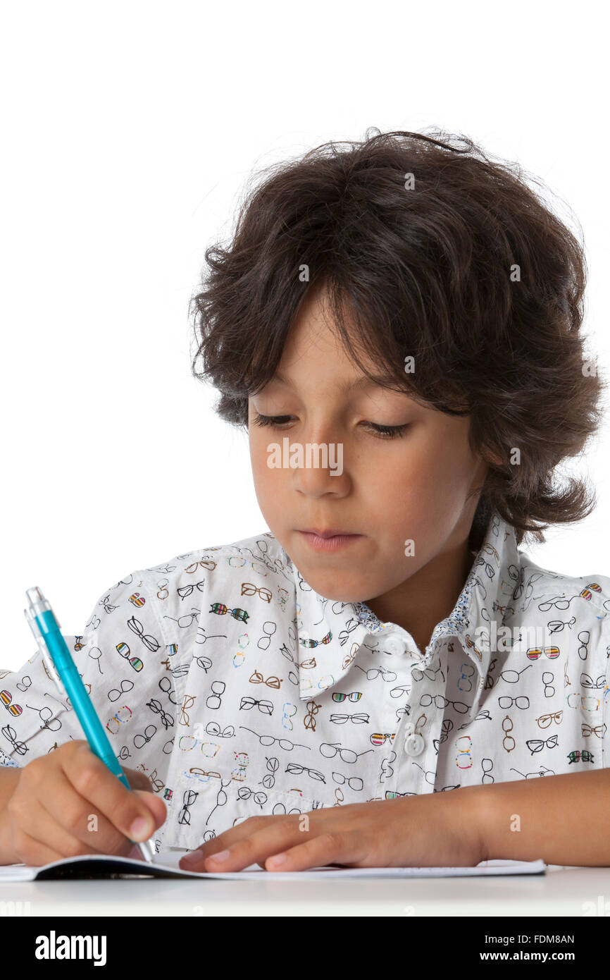 Petit garçon est écrit dans son livre d'exercice sur fond blanc Banque D'Images