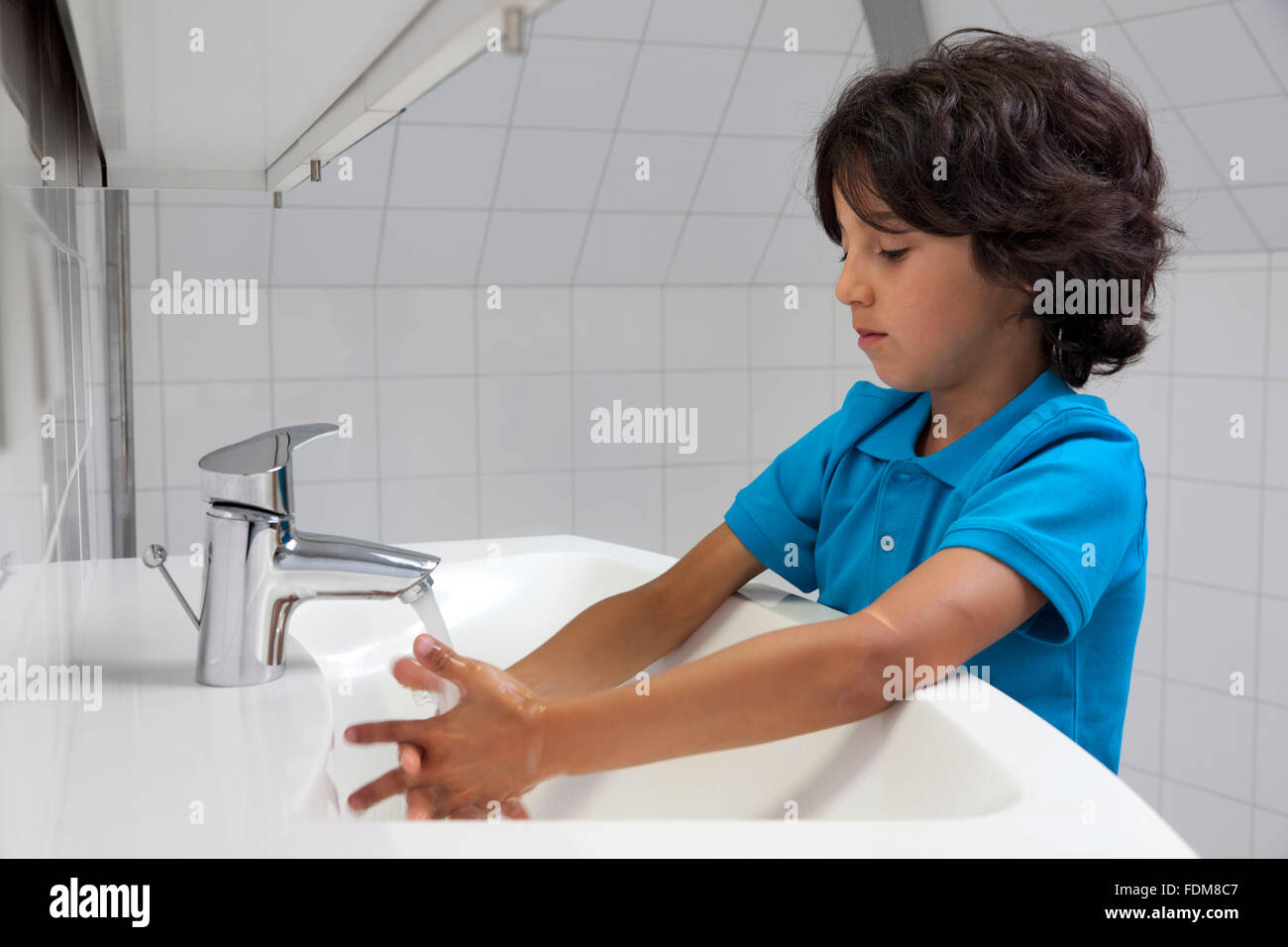 Petit garçon de laver ses mains dans la salle de bains Banque D'Images