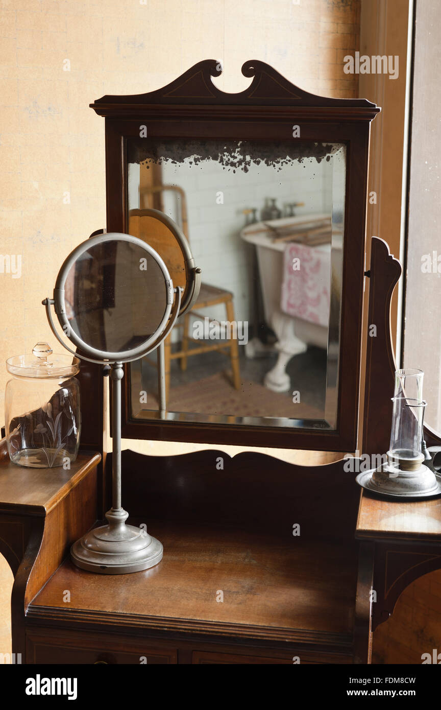 Petit miroir tournant sur un meuble de salle de bain dans la salle de bains à Dunham Massey, Cheshire. Banque D'Images