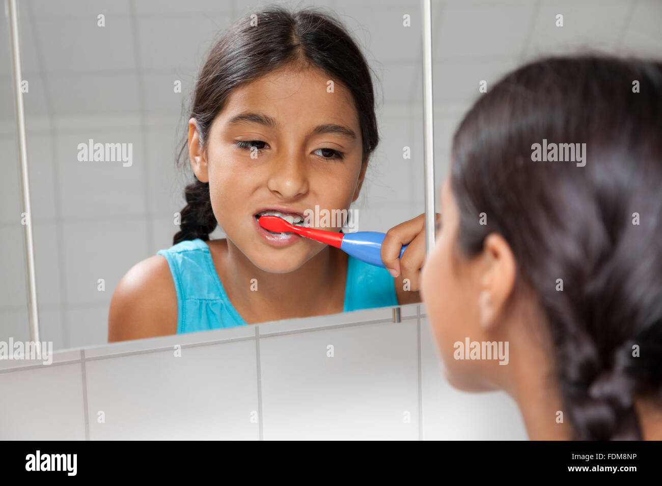 Jeune adolescente se brosser les dents dans la salle de bains Banque D'Images