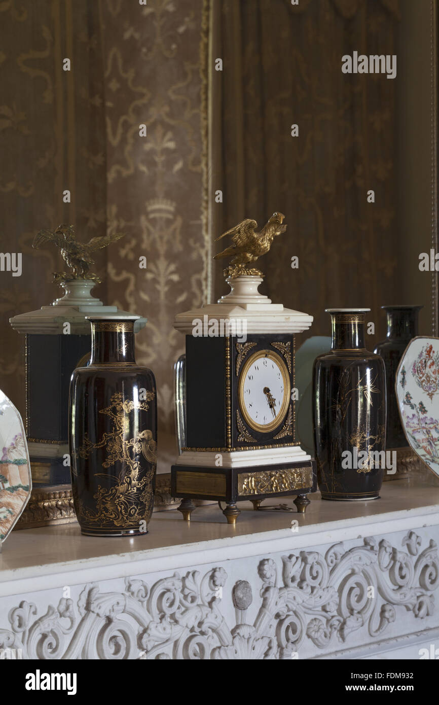 De style Empire en marbre noir et blanc, sur la pendule de la cheminée dans la chambre jaune à Belton House, Lincolnshire. Le miroir au-dessus de la cheminée présente le reflet de la double pendaisons. Banque D'Images