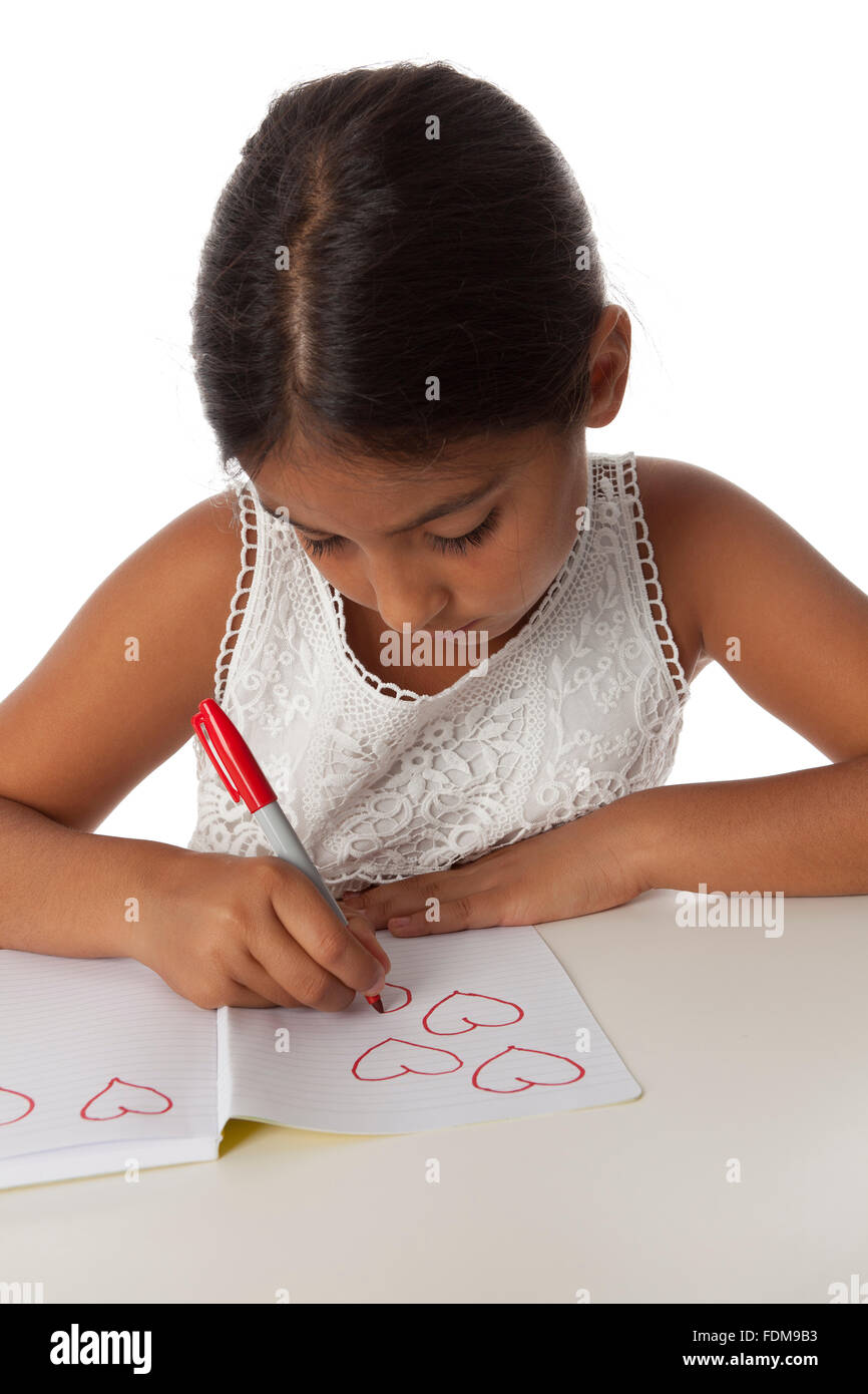 Jeune adolescente dimensions petit coeur dans son livre de note sur fond blanc Banque D'Images