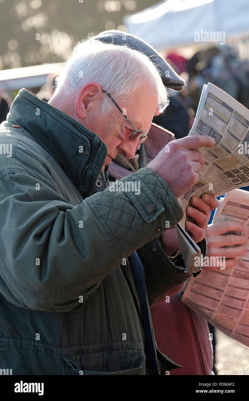 La lecture des journaux sportifs parieurs à fakenham races, North Norfolk, Angleterre Banque D'Images