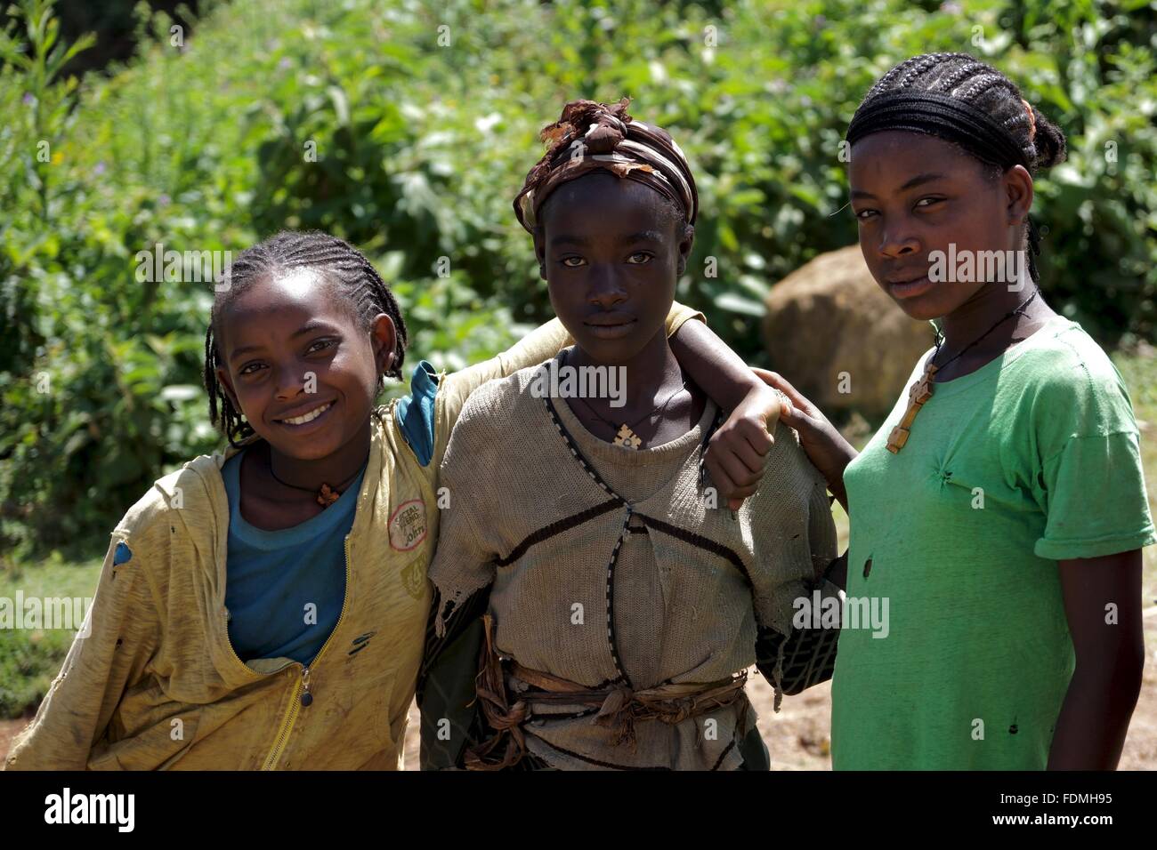 Trois jeunes filles posent pour une photographie sur le côté d'une route à travers les montagnes près de Arba Minch en Ethiopie Banque D'Images