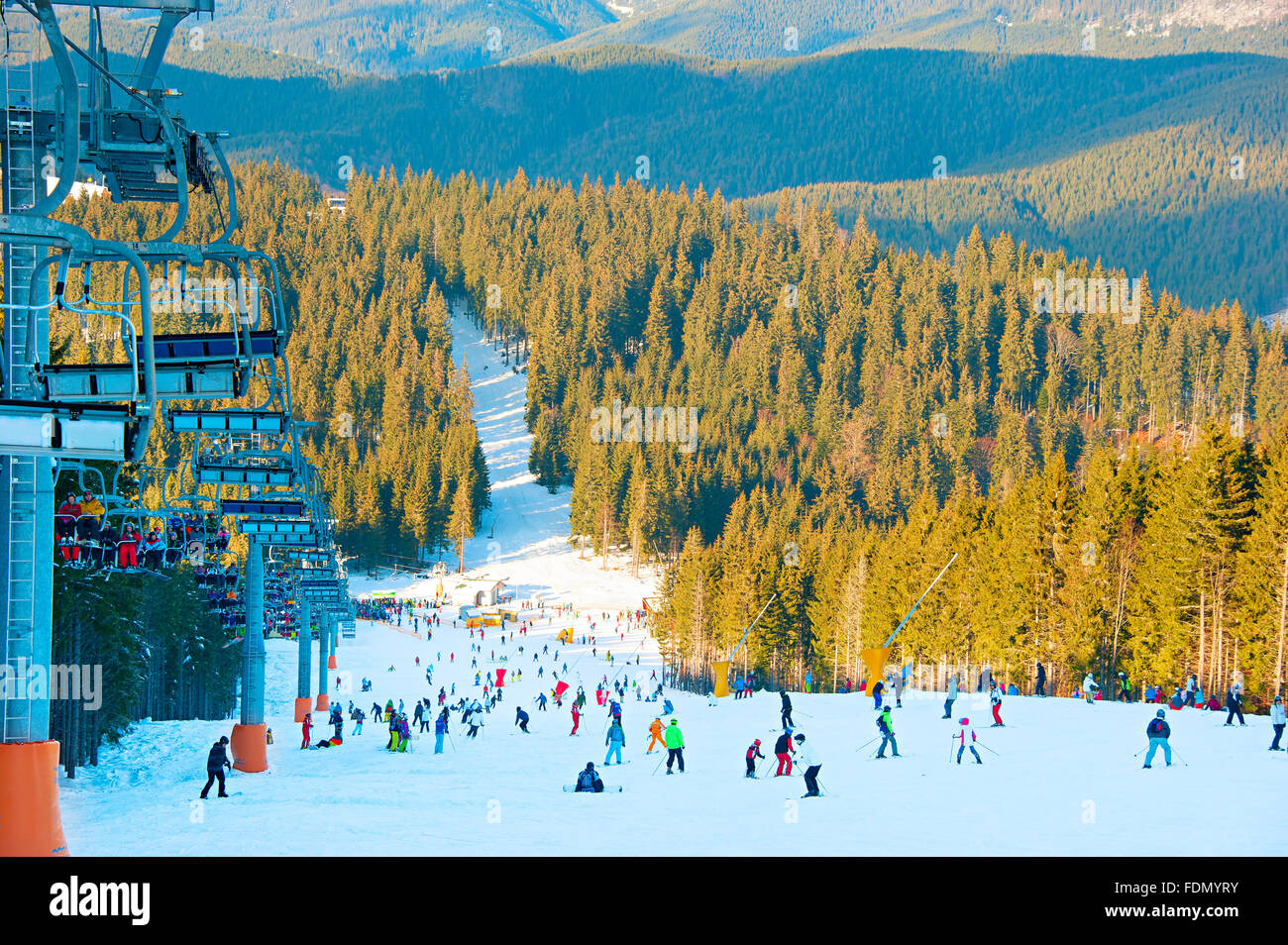 De nombreux skieurs et snowboarders sur un versant de montagne à ski resort Banque D'Images