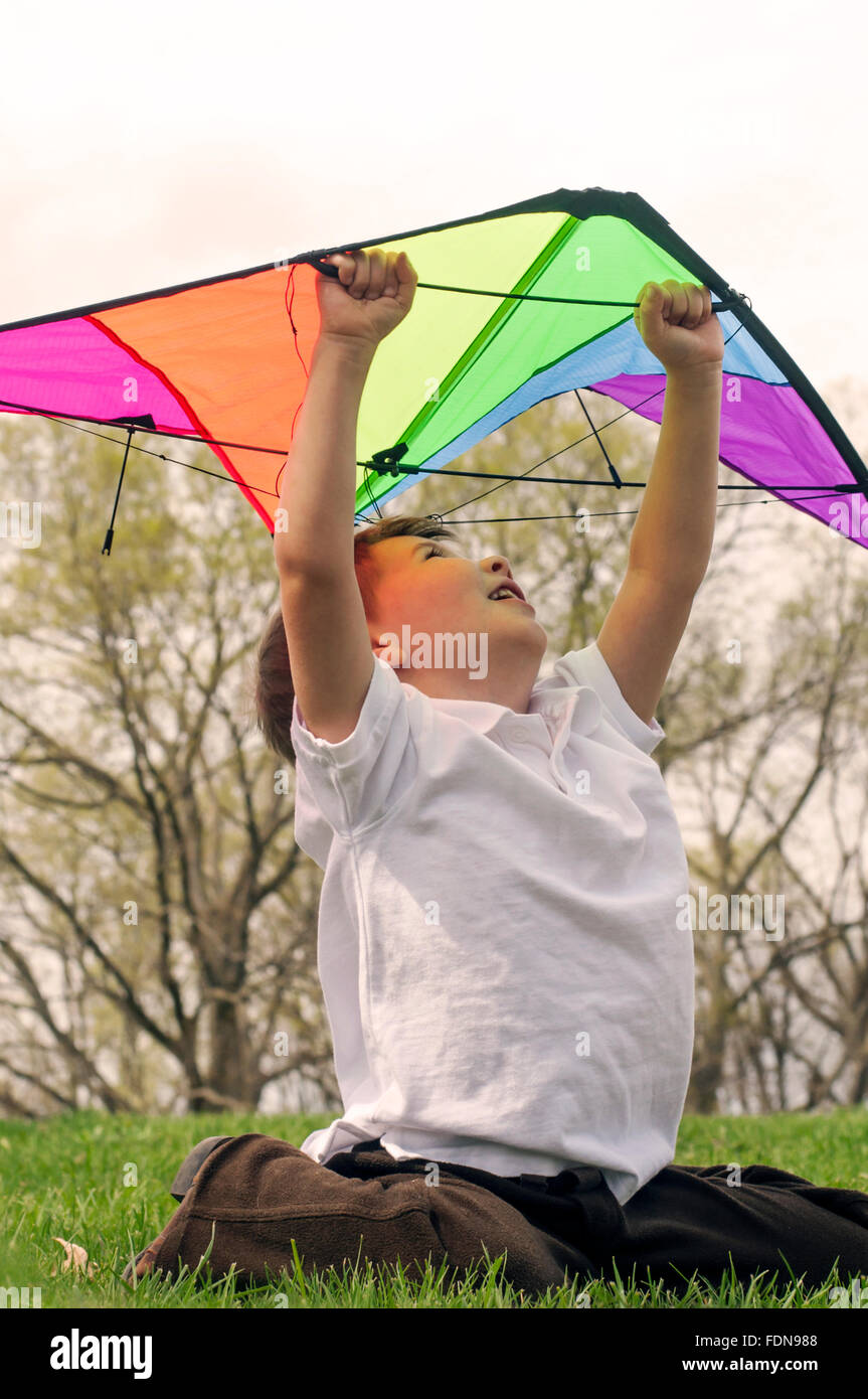 Boy looking up holding kite Banque D'Images