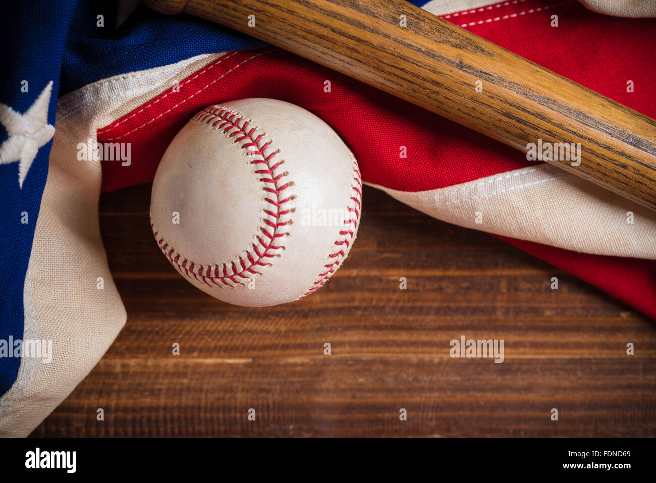 Un vieux, antique vintage drapeau américain avec l'équipement de base-ball sur un banc en bois Banque D'Images