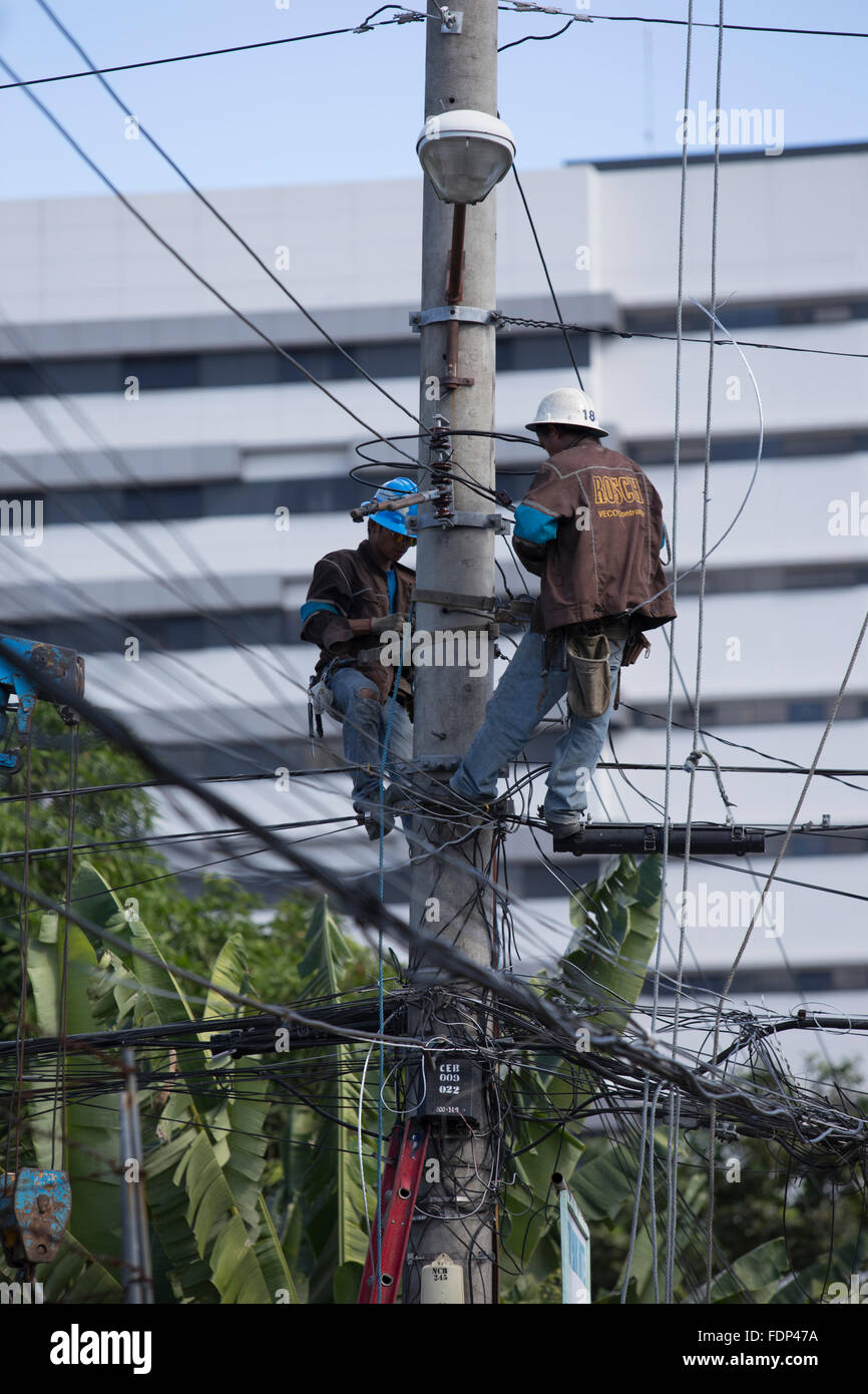 La ville de Cebu, Philippines,Société d'électricité employés travaillant sur des lignes électriques aériennes. Banque D'Images