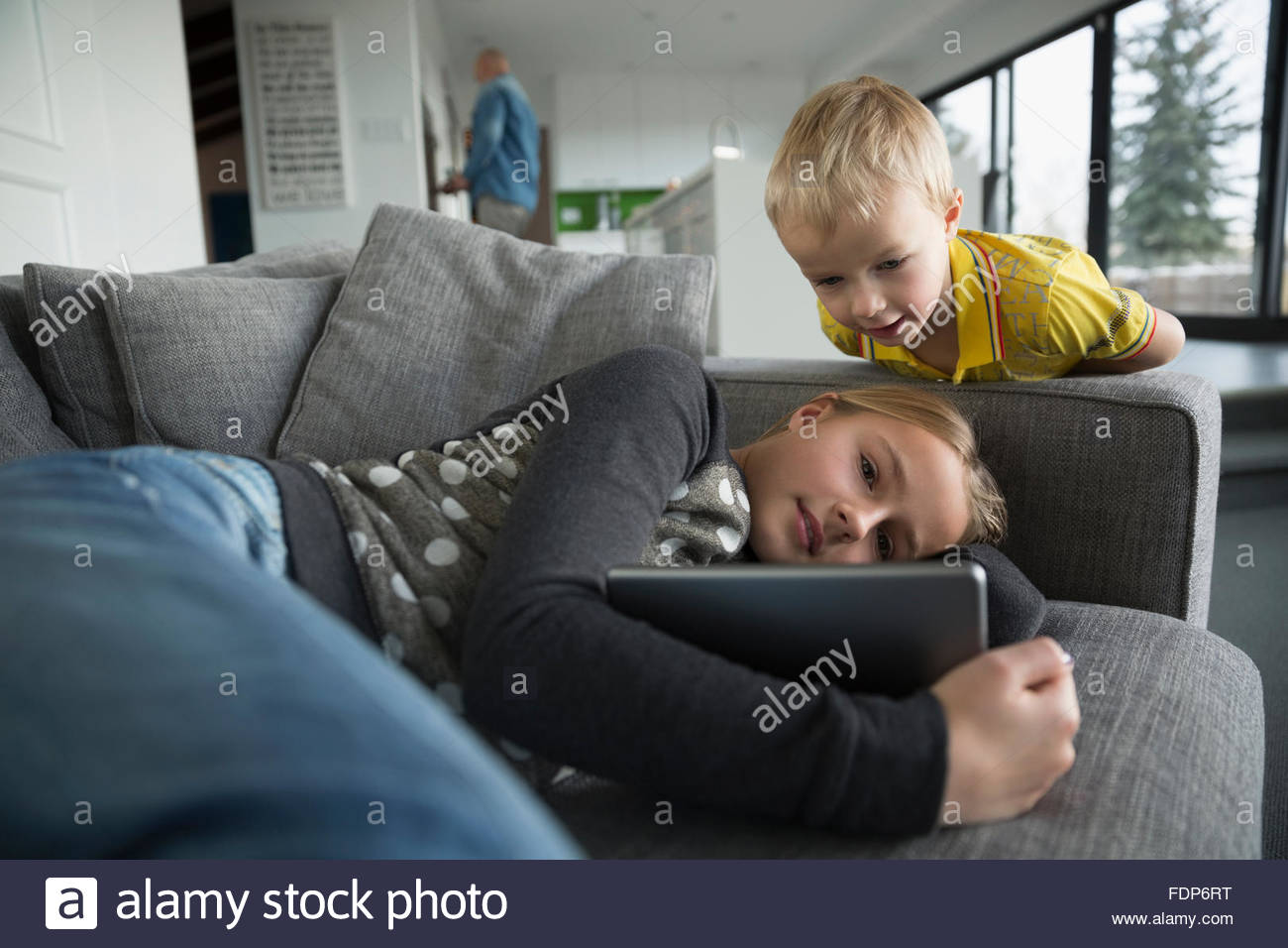 Frère et soeur regardant digital tablet on sofa Banque D'Images