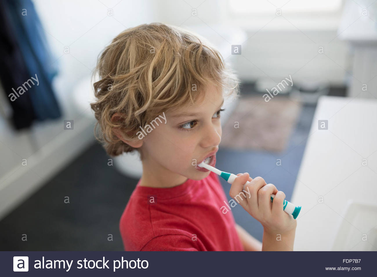 Garçon se brosser les dents dans la salle de bains Banque D'Images
