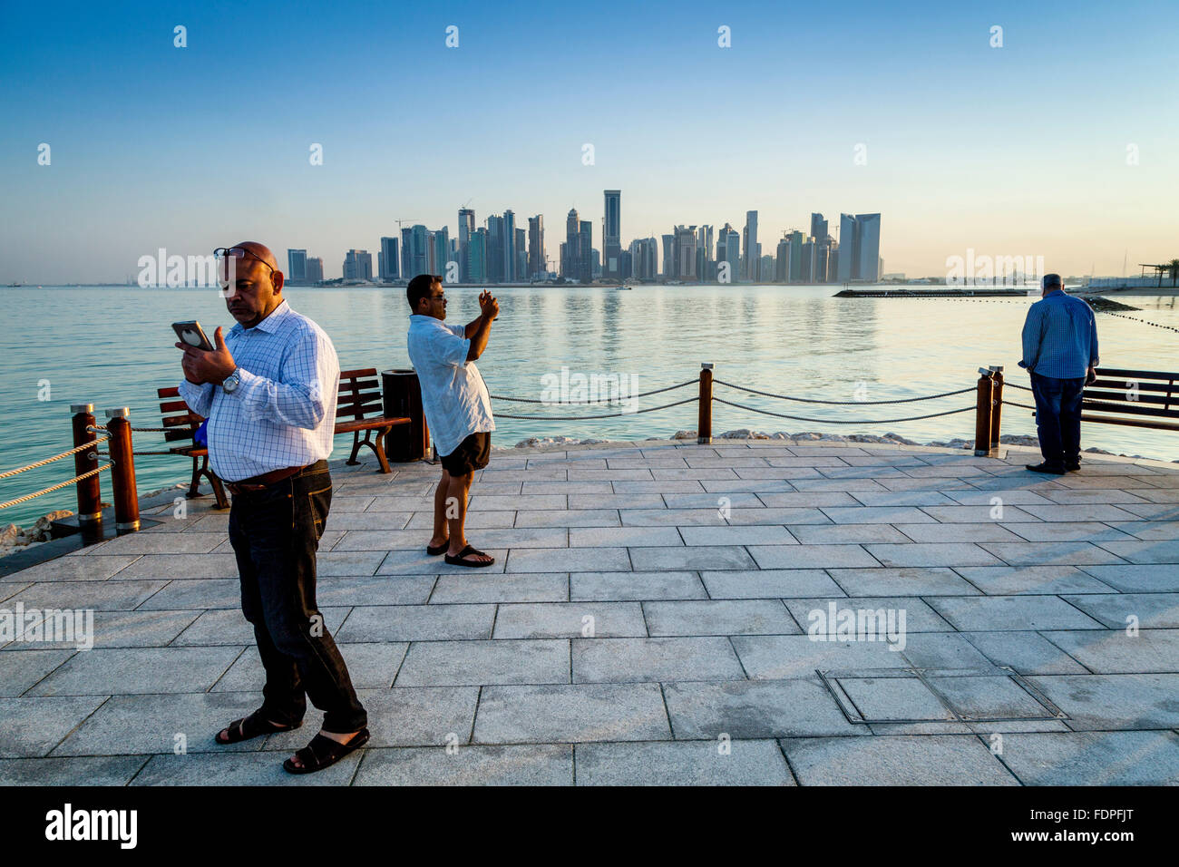 Les touristes de prendre des photos avec les gratte-ciel de West Bay, dans le contexte, Doha, Qatar Banque D'Images