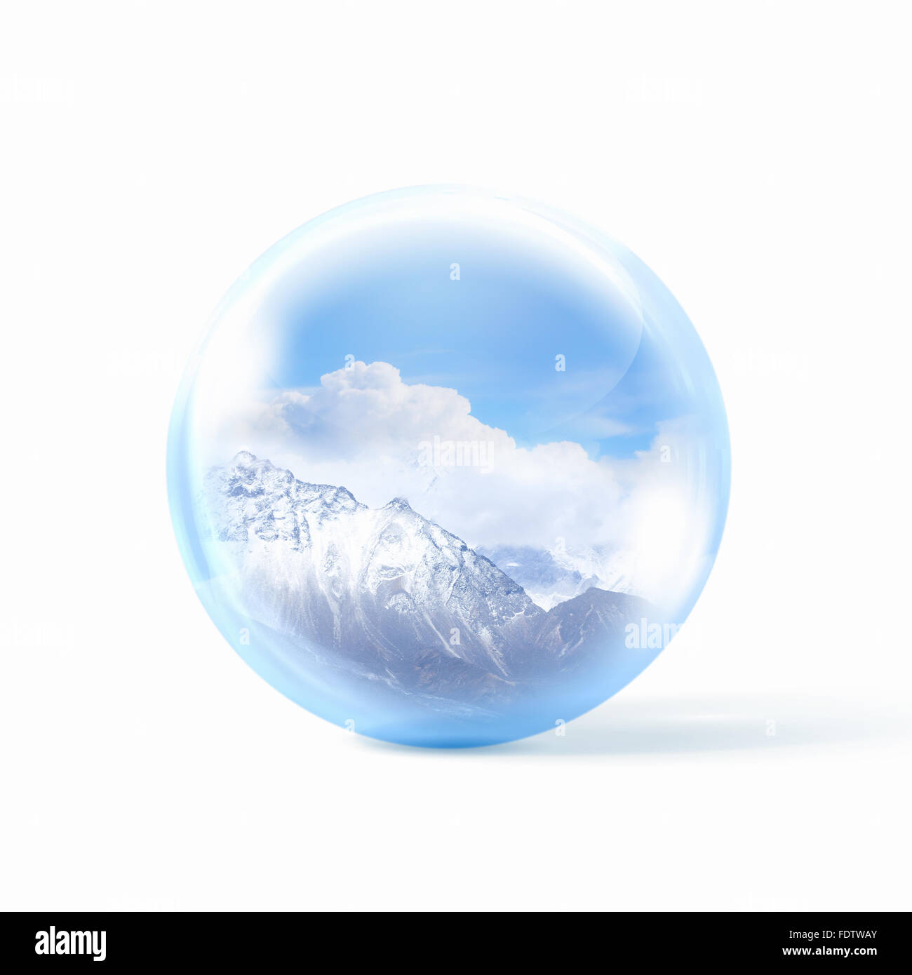 Une boule de neige en verre transparent avec de hautes montagnes à l'intérieur. Banque D'Images