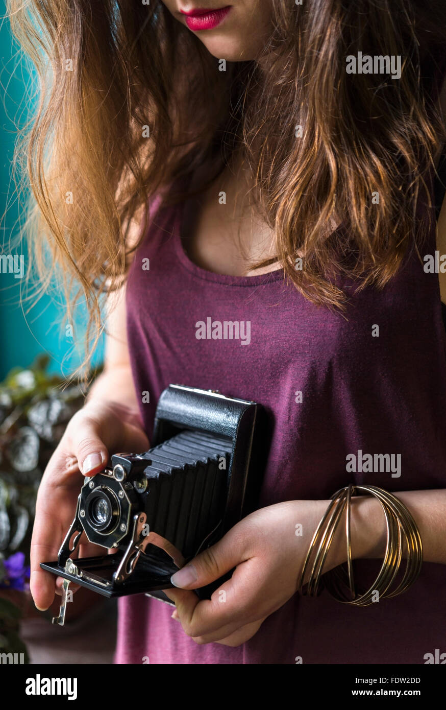 Jeune femme hands holding vintage appareil photo et prendre des photos à l'intérieur Banque D'Images