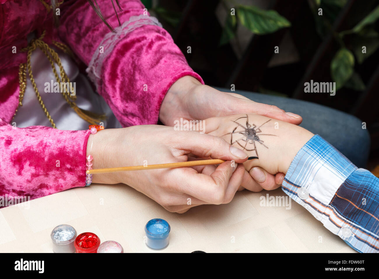 Femme attire une araignée sur fille main Banque D'Images