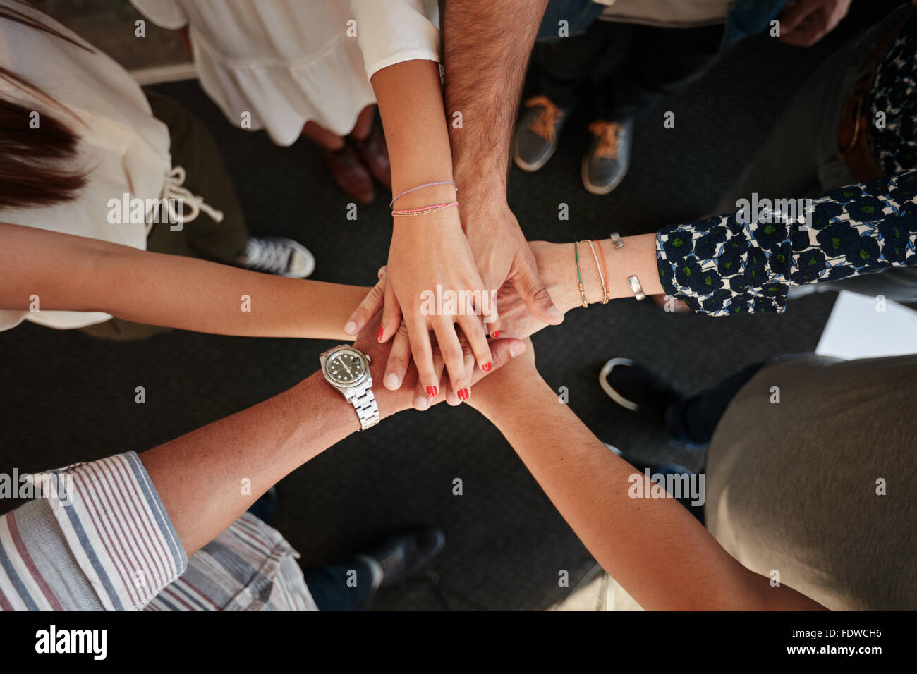 Vue supérieure de jeunes créateurs professionnels mettent leurs mains ensemble comme un symbole de l'équipe, la coopération et l'unité. Pile d'h Banque D'Images