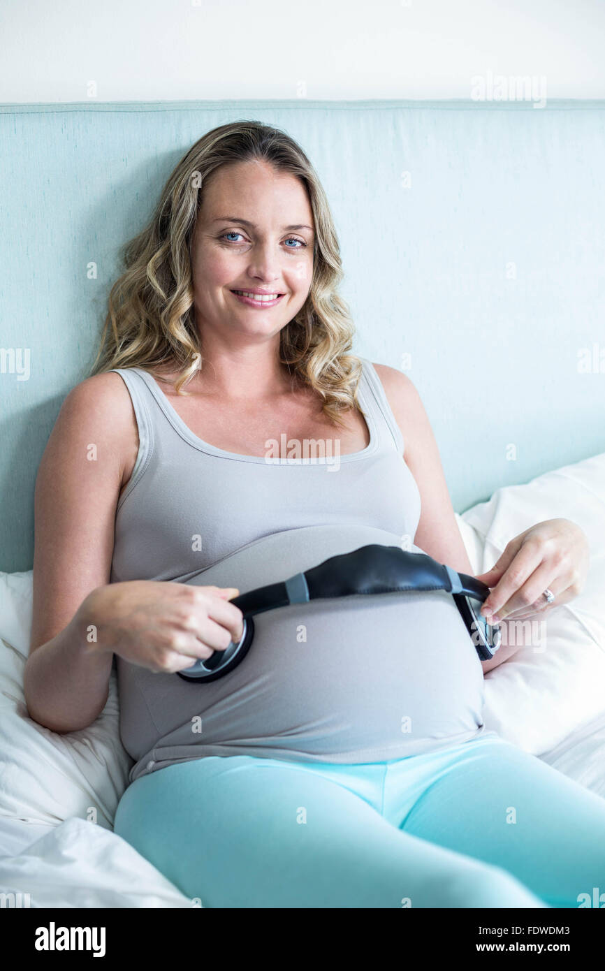 Femme enceinte faire son ventre d'écouter de la musique Banque D'Images