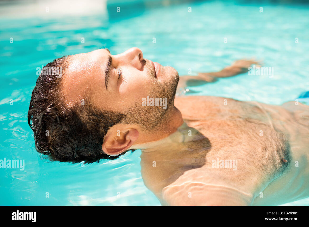 L'homme paisible flottant dans la piscine Banque D'Images