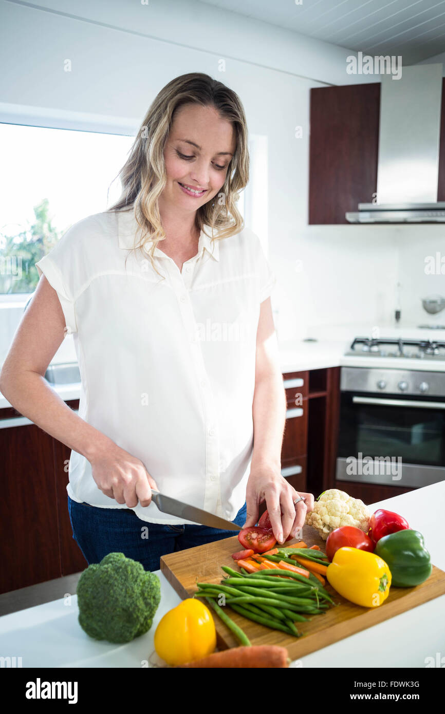 Pregnant woman cutting vegetables Banque D'Images