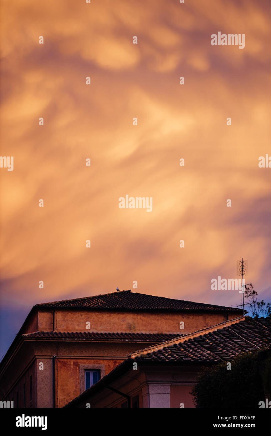 Orange dramatique nuages de tempête sur sol carrelé toits de Rome, Italie Banque D'Images