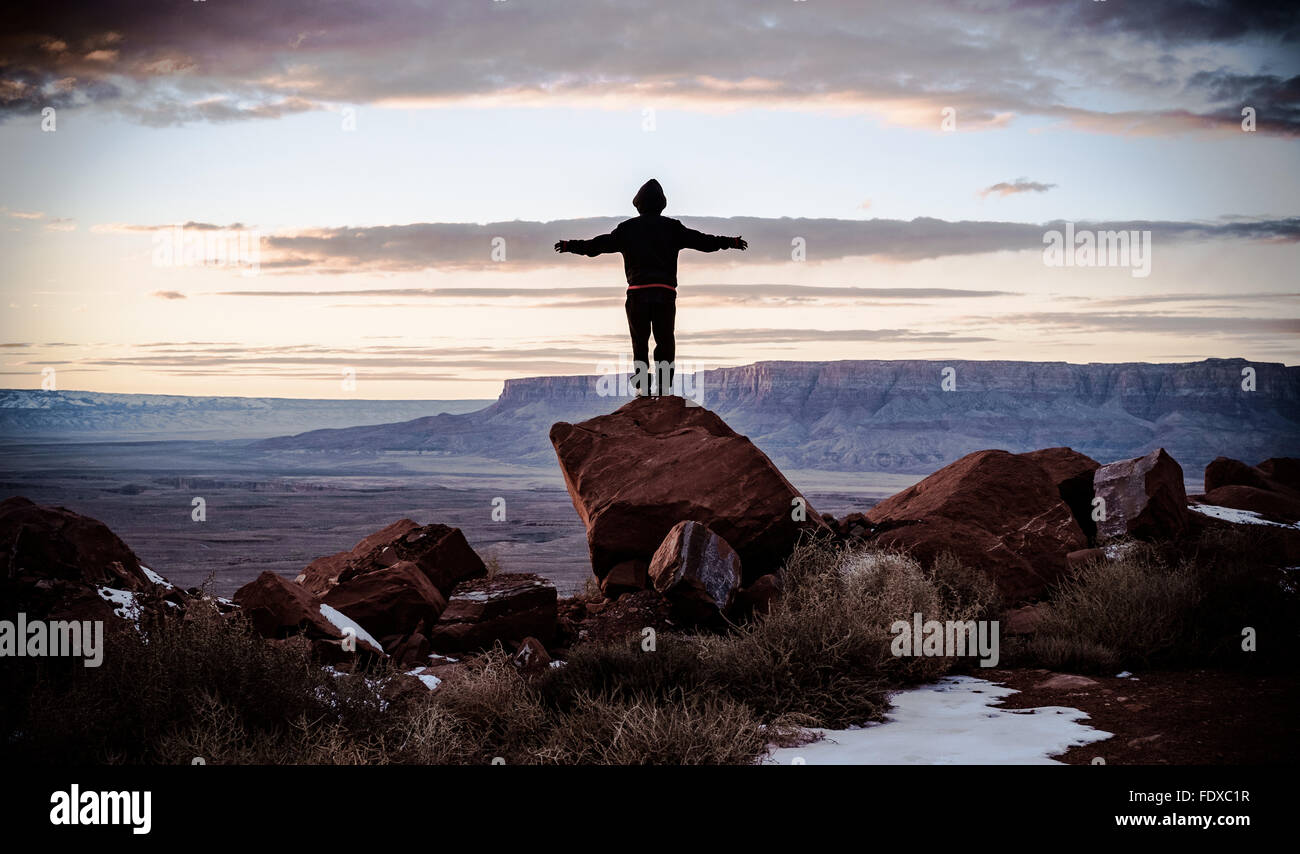 Garçon debout sur un rocher est à la paysage magnifique au coucher du soleil Banque D'Images