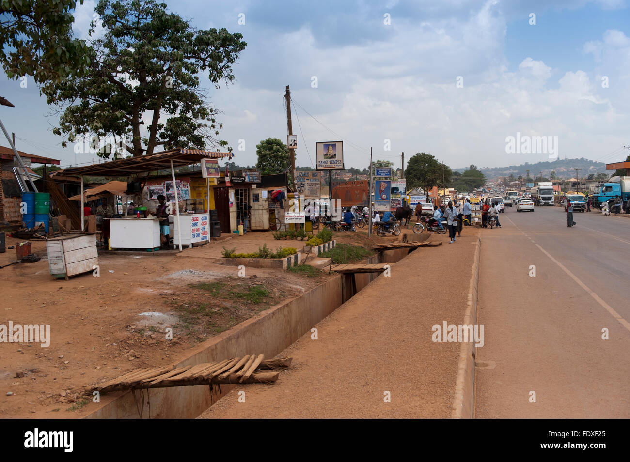 Route de village dans les régions rurales de l'Ouganda, montrant magasins et boutiques le long d'une route poussiéreuse. Banque D'Images