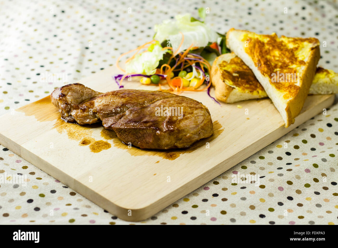 Les steaks grillés sur bois avec salades et de pain Banque D'Images