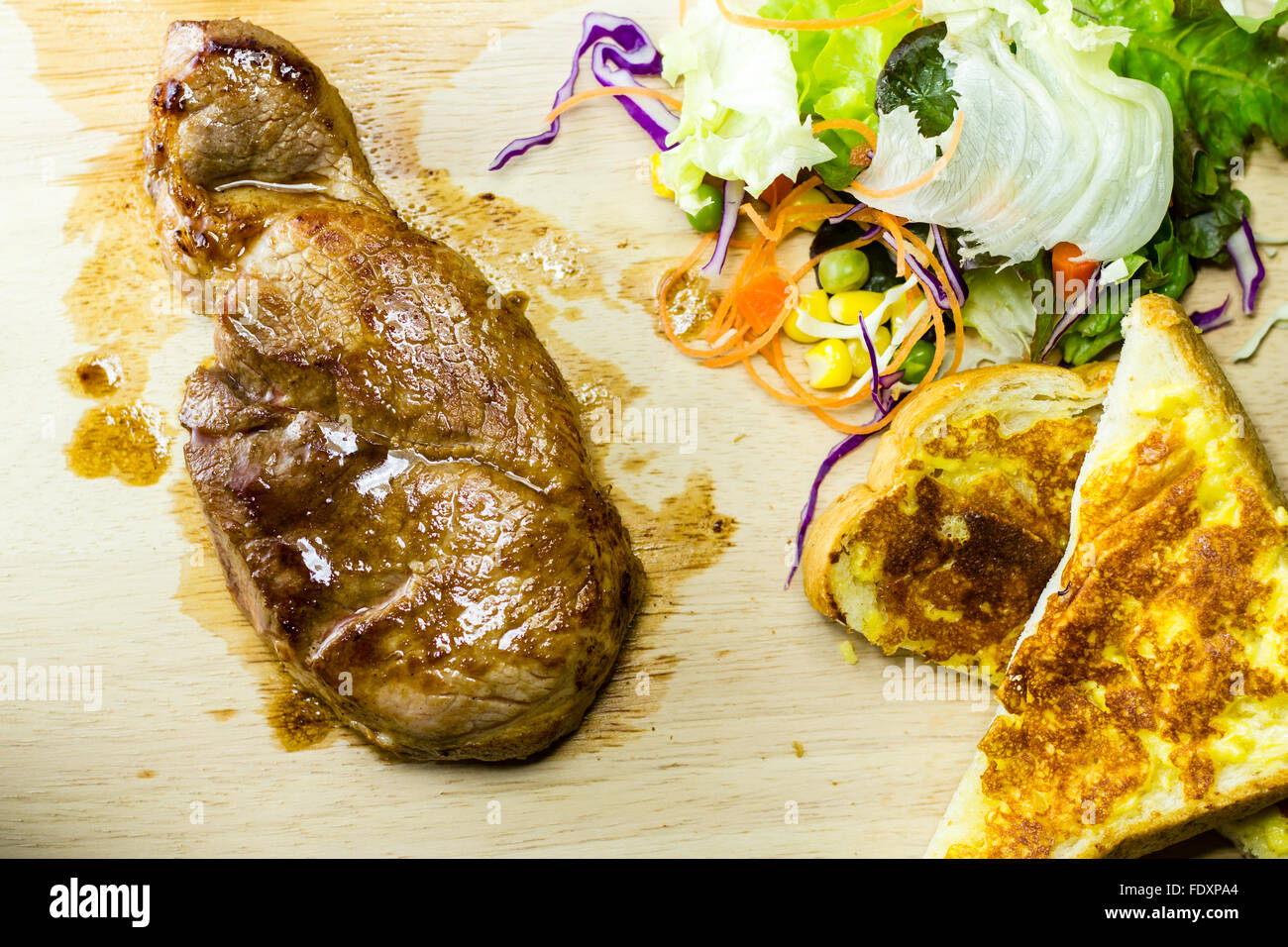 Les steaks grillés sur bois avec salades et de pain Banque D'Images