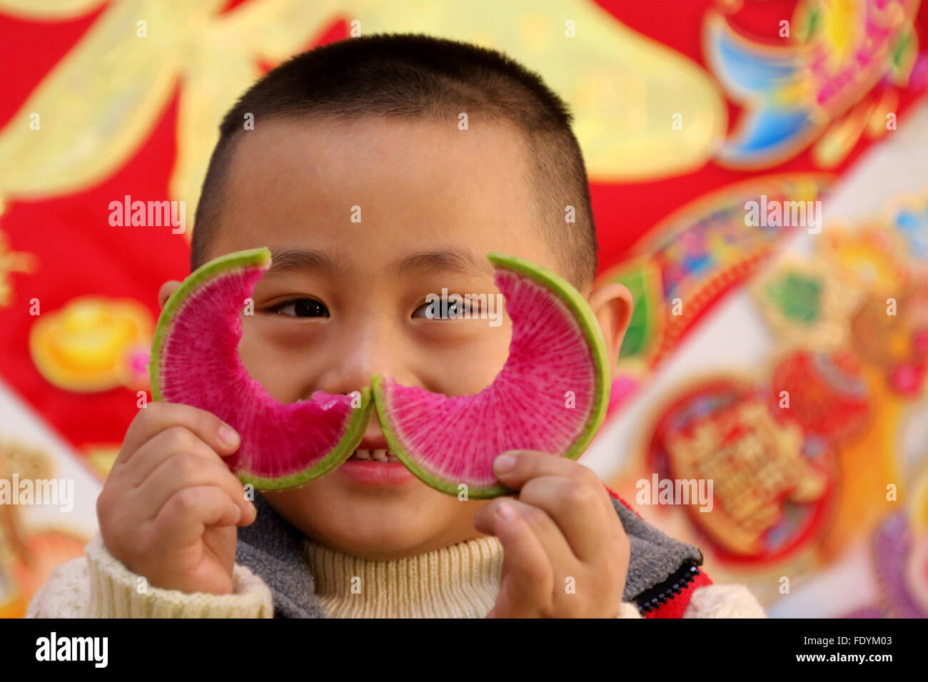 Zaozhuang. 3, 2016. Un garçon montre un morceau de navet mordu dans un jardin de Zaozhuang City, Shandong Province de Chine orientale, 3 février. Le "début du printemps" tombe le 4 février cette année. Les habitudes de manger des navets et des gâteaux de printemps le jour était censé apporter la bonne fortune. © Sun Yang/Xinhua/Alamy Live News Banque D'Images