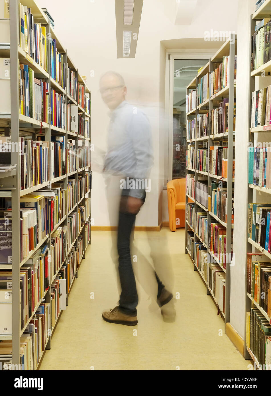 Homme debout et reading book in library à Pula. Banque D'Images