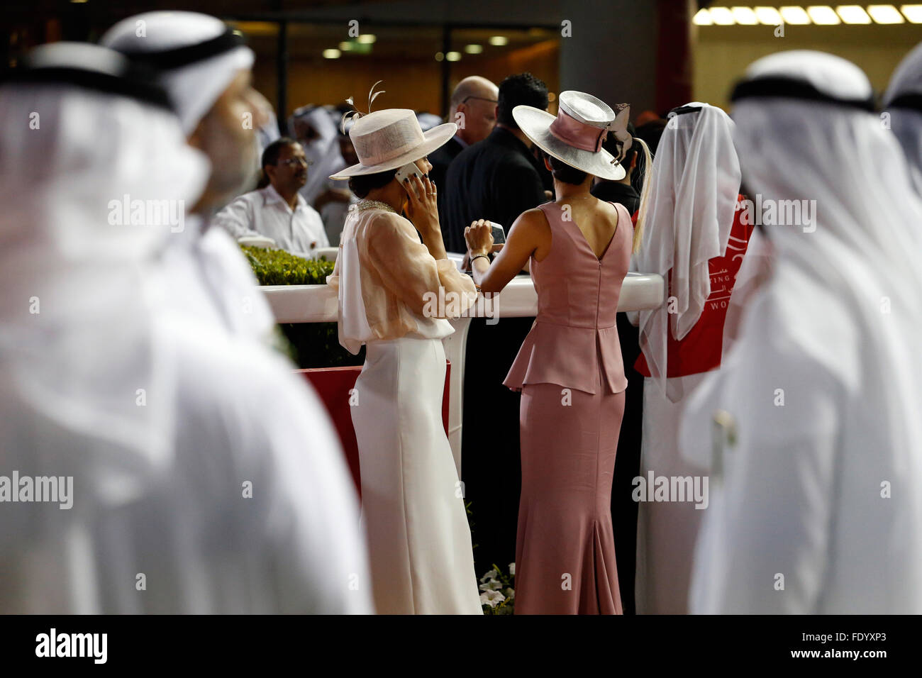 Dubaï, Émirats Arabes Unis, les hommes en costume traditionnel et les  femmes élégamment vêtu avec chapeau aux courses Photo Stock - Alamy